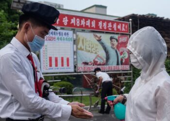 Students of the Pyongyang Jang Chol Gu University of Commerce receives hand sanitiser before entering the campus, as part of preventative measures against Covid-19, in Pyongyang on August 11, 2021. (Photo by KIM Won Jin / AFP) (Photo by KIM WON JIN/AFP via Getty Images)