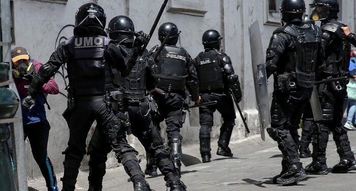 AME2116. QUITO (ECUADOR), 25/05/2020.- Miembros de la policía intentar reprimir una protesta contra el Gobierno de Lenín Moreno este lunes, en Quito (Ecuador). Miles de ecuatorianos han salido a las calles para protestar contra los despidos y las políticas de austeridad aplicadas por el Gobierno, en un desafío también a la amenaza de contagio del COVID-19 que ha cobrado la vida de más de 3.200 personas e infectado a más de 37.300 en el país. Protegidos con mascarillas y tratando de mantener una distancia de dos metros, los manifestantes han acusado al Gobierno de obligar a la población a salir a las calles a protestar contra las medidas aplicadas en medio de la pandemia. EFE/ Jose Jacome