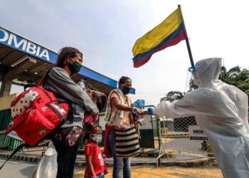 Staffers from Colombia's Secretary of Health check Venezuelans while leaving Colombia and returning to their country, as a preventive measure against the spread of the COVID-19 coronavirus, at the Simon Bolivar International Bridge, in Cucuta, Colombia-Venezuela border, on April 28, 2020. (Photo by Schneyder MENDOZA / AFP) (Photo by SCHNEYDER MENDOZA/AFP via Getty Images)