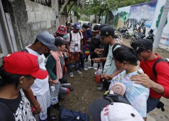 Fotografía del 12 de octubre de 2022 que muestra a migrantes venezolanos que rezan antes de iniciar un recorrido con la intención de llegar a Panamá para emprender una travesía con destino final en Estados Unidos, el 8 de octubre de 2022, a través del Tapón del Darién (Colombia). Moisés tardó 21 días en llegar desde Venezuela a México, en ruta hacia Estados Unidos, igual que otros migrantes que se enfrentan a un duro trayecto que recorren a ratos a pie, a caballo, en piragua, en bus y hasta en una carreta, en busca del sueño americano, del que muchos despertaron de golpe tras el anuncio de la nueva política migratoria del Gobierno norteamericano, que limita sus posibilidades de éxito. EFE/ Mauricio Dueñas Castañeda