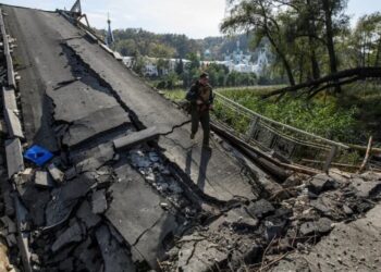 Un miembro del servicio de la Guardia Nacional de Ucrania camina por un puente sobre el río Siverskyi Donets destruido durante el ataque de Rusia a Ucrania, en la ciudad de Sviatohirsk, región de Donetsk, Ucrania 1 de octubre de 2022. REUTERS/Vladyslav Musiienko