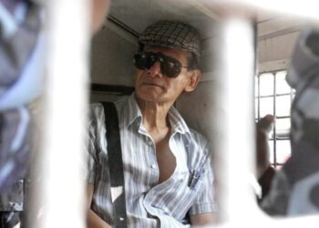 El asesino en serie francés Charles Sobhraj se sienta en una camioneta de la policía. Foto agencias.