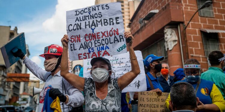 Demonstrators protest for resuming classes without coronavirus control enough measures, in Caracas, Venezuela, 5 October 2020. Sign reads: 'Teachers and students suffering hunger and without internet connectivity. Scholar period is a deception'. Little groups of teachers, joint by other demonstrators, tried to parade in protest for resuming classes without bio-security measures, lacking provisions, and low incomes. Still, Government supporters occupied the square where demonstrators planned to get together. EFE/ Miguel Gutierrez