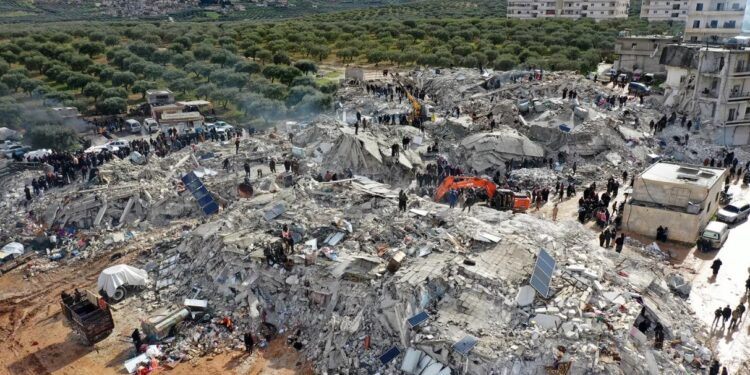 Esta vista aérea muestra a los residentes, ayudados por equipos pesados, buscando víctimas y sobrevivientes entre los escombros de los edificios derrumbados luego de un terremoto en la aldea de Besnia, cerca de la ciudad de Harim, en la provincia noroccidental de Idlib en Siria, controlada por los rebeldes, en la frontera con Turquía.