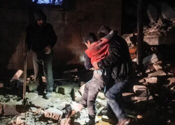 Un hombre se lleva a un niño herido luego de un terremoto en la ciudad de Jandaris, en el campo de la ciudad de Afrin, en el noroeste de Siria, en la parte rebelde de la provincia de Alepo..