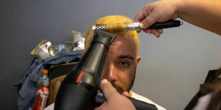 Un seguidor de la selección de béisbol de Puerto Rico se hace teñir el cabello junto con otras decenas de personas, para romper el récord Guinness en Guaynabo, el viernes 10 de marzo de 2023 (AP Foto/Alejandro Granadillo) AP (Alejandro Granadillo/AP)