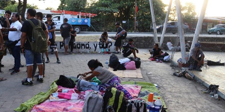 MEX8020. HUIXTLA (MÉXICO), 01/03/2023.- Personas migrantes de diversas nacionalidades permanecen en un espacio deportivo hoy, en el municipio de Huixta, estado de Chiapas (México). La primera caravana de 2023, que partió desde Tapachula con unos 1.000 migrantes, se detuvo este miércoles en la localidad de Huixtla, en Chiapas, sur de México, ante un temor por la inseguridad en el país. EFE/ Juan Manuel Blanco