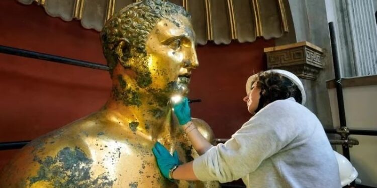 La restauradora del Museo Vaticano Alice Baltera trabaja en la estatua de bronce de Hércules, en la Sala Redonda de los Museos Vaticanos, el jueves 11 de mayo de 2023 (AP Photo Andrew Medichini)