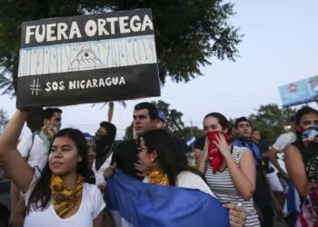 A woman holds a sign that reads in Spanish  Ortega Out   during a protest against the government of President Daniel Ortega  in Managua  Nicaragua  Sunday  April 11  2018  President Ortega has withdrawn changes to the social security system that touched off protests across the Central American nation that escalated into clashes with police leaving dozens dead   AP Photo Alfredo Zuniga