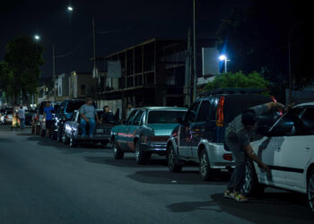 AME7989. MARACAIBO (VENEZUELA), 21/06/2023.- Un grupo de hombres pernoctan en una fila junto a sus vehículos mientras esperan para surtir combustible, 13 de junio de 2023, en Maracaibo (Venezuela). El "normal funcionamiento" de las gasolineras en Venezuela, reportado por la estatal Pdvsa, contrasta con las largas colas de vehículos que deben esperar varias horas para repostar, en regiones del interior del país, donde, según expertos y trabajadores de la industria, la crisis del combustible se ha convertido en rutina. EFE/ Henry Chirinos