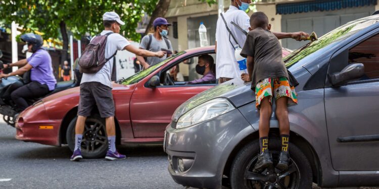 Varios niños y jóvenes limpian las ventanas de los carros el 6 de octubre de 2021, en una calle de Caracas (Venezuela). EFE/ Miguel Gutiérrez