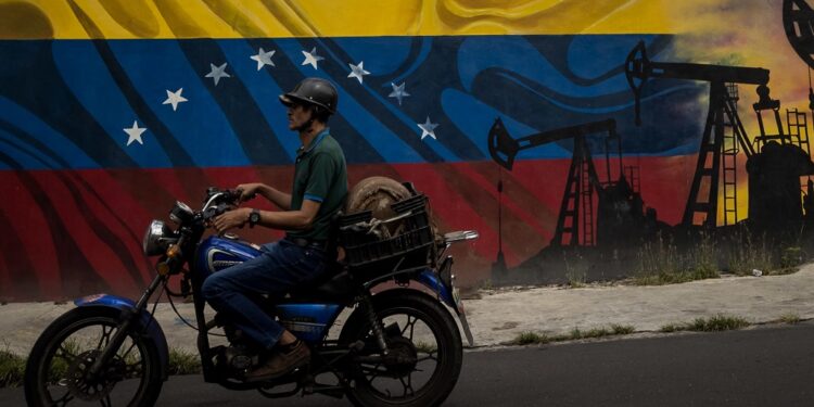 AME6708. CARACAS (VENEZUELA), 31/07/2023.- Un motociclista pasa frente a un mural en el Complejo MinPetróleo - Petróleos de Venezuela S.A. (Pdvsa), el 27 de julio de 2023 en Caracas (Venezuela). La gallina de los huevos de oro de Venezuela, la industria petrolera, ha estado sobre el tapete en las últimas semanas, cuando candidatos a las primarias opositoras han debatido sobre si convendrá o no su privatización, una opción que algunos aspirantes tienen como meta en caso de llegar a la Presidencia. EFE/ MIGUEL GUTIÉRREZ