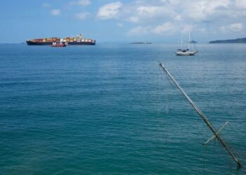 El mástil de un barco hundido sobresale en el agua mientras un buque de carga navega hacia el océano Pacífico tras su paso por el Canal de Panamá, visto desde Ciudad de Panamá, el jueves 3 de agosto de 2023. | Foto: AP