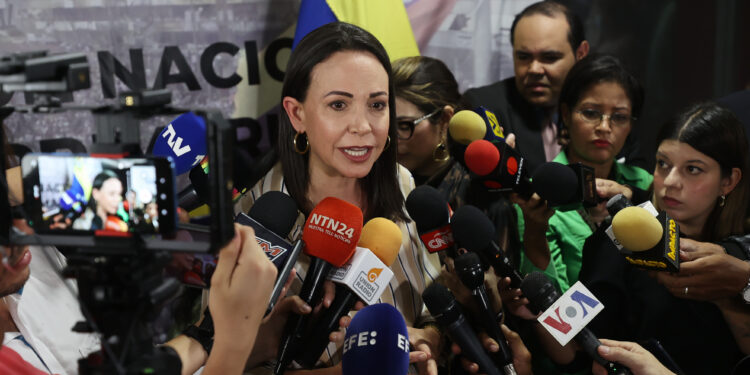 AME8089. CARACAS (VENEZUELA), 04/08/2023.- La precandidata presidencial opositora María Corina Machado habla con la prensa luego de un acto político hoy, en Caracas (Venezuela). Los 13 candidatos a las primarias opositoras del 22 de octubre, que definirán al abanderado que se enfrentará al chavismo en las presidenciales de 2024, firmaron este viernes un documento con los "principios comunes" que regirán su programa de Gobierno, en caso de ganar los comicios del próximo año. El acuerdo suscrito establece que el país "debe avanzar en cambios que consoliden un nuevo modelo político, económico y social", siempre que sea "sobre la base de unos principios comunes, a partir de los cuales la candidatura unitaria (quien resulte vencedor en octubre) diseñará su programa de reformas estructurales". EFE/ Miguel Gutiérrez