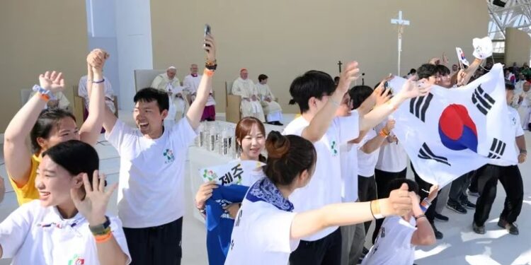 La gente muestra una bandera de Corea del Sur para anunciar el anfitrión de la próxima Jornada Mundial de la Juventud mientras el Papa Francisco dirige la santa misa para la Jornada Mundial de la Juventud en el Parque Tejo durante su viaje apostólico a Portugal con motivo de la XXXVII Jornada Mundial de la Juventud, en Lisboa, Portugal. , 6 de agosto de 2023. Vatican Media/Folleto vía REUTERS