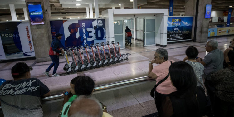 ACOMPAÑA CRÓNICA: VENEZUELA MIGRACIÓN. AME2346. MAIQUETIA (VENEZUELA), 18/08/2023.- Personas esperan en el Aeropuerto Internacional Simón Bolivar, el 14 de agosto de 2023, en Maiquetia (Venezuela). El caraqueño Daniel Zambrano sueña con un futuro para él y su familia en España, a donde planea llegar el próximo año, con el objetivo de alcanzar la "estabilidad mental" que dice haber perdido en Venezuela, ante las dificultades para hacer frente a los gastos del hogar, a pesar de contar con cuatro fuentes de ingreso. Mientras, algunos de los que habían migrado han regresado atraídos por la ligera mejora económica. EFE/ Miguel Gutiérrez