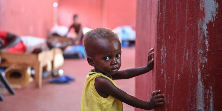 Nineteen-month-old David stands inside the Fontaine Hospital Center in the Cite Soleil slum in Port-au-Prince on August 4, 2023. In Cite Soleil, the largest slum in the gang-infested Haitian capital, the early days of August have brought a grim flow of skeletally malnourished children to the Fontaine Hospital Center. 
The community clinic, a reassuring presence in this poorest corner of Port-au-Prince for more than 30 years, offers rare respite to inhabitants who now face daily threats from the armed groups controlling much of the city. (Photo by Richard PIERRIN / AFP)