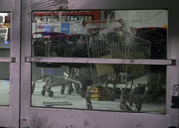 Picture of the broken glass of door at a "Dia" supermarket taken after it was looted, in Jose C. Paz on the outskirts of Buenos Aires on August 22, 2023. Almost thirty people were arrested in Argentina after looting of commercial premises over the weekend in the provinces of Cordoba and Mendoza, events which the government described as "criminal acts" aimed at creating confusion in the midst of the campaign for the October presidential elections. An attempt to loot a store in Buenos Aires was reported on Monday night, which was prevented by neighbours. (Photo by Juan MABROMATA / AFP)