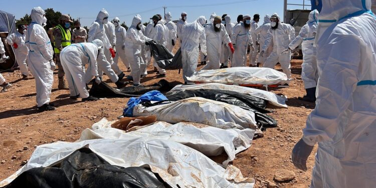 Derna (Libyan Arab Jamahiriya), 16/09/2023.- Rescuers stand near bodies of victims who died after Storm Daniel swept across eastern Libya, before burying the victims in mass graves, in the port city of Derna, eastern Libya, 16 September 2023. Unprecedented floods struck Libya after Mediterranean Storm Daniel made landfall on 10 September. Intense rainfall from the storm in the country's eastern region caused the collapse of two dams south of the city of Derna, sweeping away entire neighborhoods. The death toll has surpassed 11,000 and over 34,000 people have been displaced across the country. The flooding exacerbated Libya's needs, where 800,000 people are reported in need of humanitarian assistance, the International Rescue Committee (IRC) said. (Inundaciones, tormenta, Libia) EFE/EPA/STRINGER