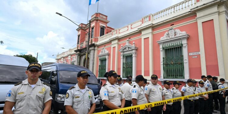 Police officers remain outside the headquarters of the Supreme Electoral Tribunal while prosecutors from the Public Ministry carry out a raid in Guatemala City on September 29,2023. Guatemalas electoral court was raided on Friday by the questioned prosecutors office to request information on the minutes of the electoral process that led to the presidency of the Social Democrat, Bernardo Arévalo, official sources reported. (Photo by Johan ORDONEZ / AFP)