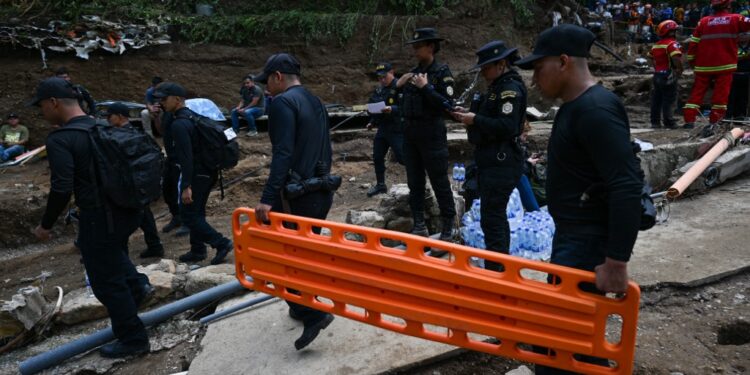 Police officers work at the site where a sewage-polluted river swollen by heavy rains swept away precarious homes at Dios es Fiel shantytown, in the Kjell Laugerud colony in Guatemala City, taken on September 25, 2023. At least six people were killed and 13 others are missing after a river overflowed due to heavy rains, sweeping away six homes in the center of Guatemala's capital. (Photo by Johan ORDONEZ / AFP)