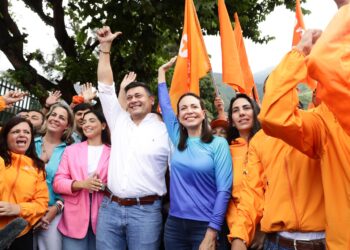 AME6822. CARACAS (VENEZUELA), 13/10/2023.- María Corina Machado junto al opositor Freddy Superlano saludan a simpatizantes, hoy, en Caracas (Venezuela). El candidato a las primarias de la oposición venezolana Freddy Superlano, inhabilitado por la Contraloría para ejercer cargos públicos, anunció este viernes que retira su candidatura para respaldar a María Corina Machado, quien también está inhabilitada. La renuncia de Superlano se produce seis días después de que Henrique Capriles anunciara también su retiro de la contienda electoral del 22 de octubre, en su caso, para dar paso a una "opción viable" de algún competidor que no esté inhabilitado para ejercer cargos públicos como él. EFE/Rayner PeñaR