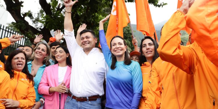 AME6822. CARACAS (VENEZUELA), 13/10/2023.- María Corina Machado junto al opositor Freddy Superlano saludan a simpatizantes, hoy, en Caracas (Venezuela). El candidato a las primarias de la oposición venezolana Freddy Superlano, inhabilitado por la Contraloría para ejercer cargos públicos, anunció este viernes que retira su candidatura para respaldar a María Corina Machado, quien también está inhabilitada. La renuncia de Superlano se produce seis días después de que Henrique Capriles anunciara también su retiro de la contienda electoral del 22 de octubre, en su caso, para dar paso a una "opción viable" de algún competidor que no esté inhabilitado para ejercer cargos públicos como él. EFE/Rayner PeñaR