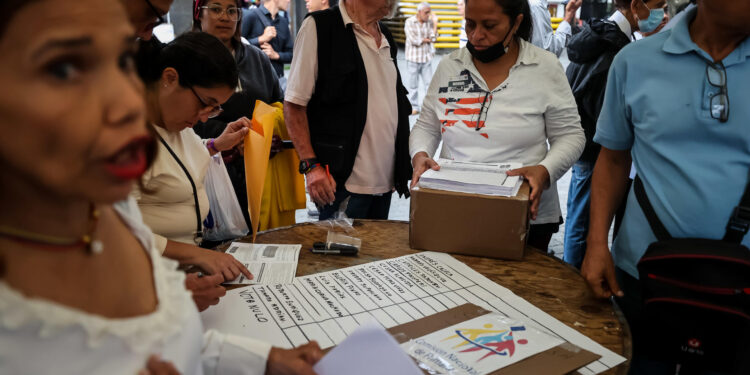 AME9666. CARACAS (VENEZUELA), 22/10/2023.- Miembros de mesas comienzan el conteo de votos durante el cierre de la jornada electoral de las primarias de la oposición, hoy, en Caracas (Venezuela). Comienzan los conteos tras el cierre de las mesas de votación para las elecciones internas de la oposición en Venezuela para escoger al candidato del antichavismo para las elecciones presidenciales del segundo semestre de 2024. A las internas de la oposición concurren 10 candidatos, de los 13 inscritos inicialmente. EFE/ Miguel Gutiérrez