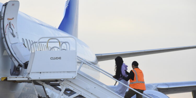 Migrantes venezolanos abordan un avión con destino a su país natal en Harlingen, Texas, el miércoles 18 de octubre de 2023. (AP Foto/Valerie Gonzalez)