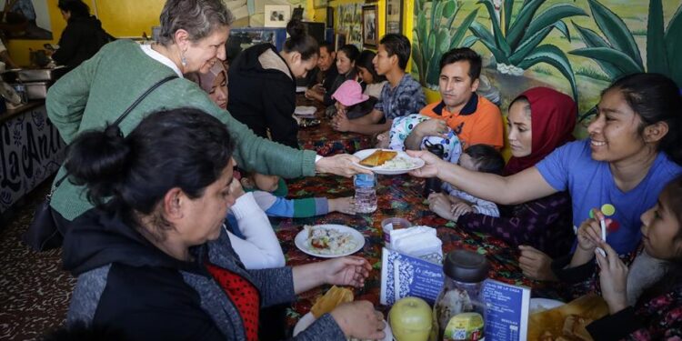 Migrantes reciben comida en la fonda La 'Antigüita' para celebrar el Día de Acción de Gracias hoy, en la ciudad de Tijuana, Baja California (México). Familias y personas migrantes que se encuentran en albergues de la fronteriza ciudad de Tijuana, a la espera de poder obtener citas para sus procesos de asilo en Estados Unidos, celebraron este jueves el tradicional 'Thanksgiving' o Día de Acción de Gracias, con una comida ofrecida por la migrante deportada Esther Morales en su restaurante conocido como La Antigüita. EFE/Joebeth Terríquez