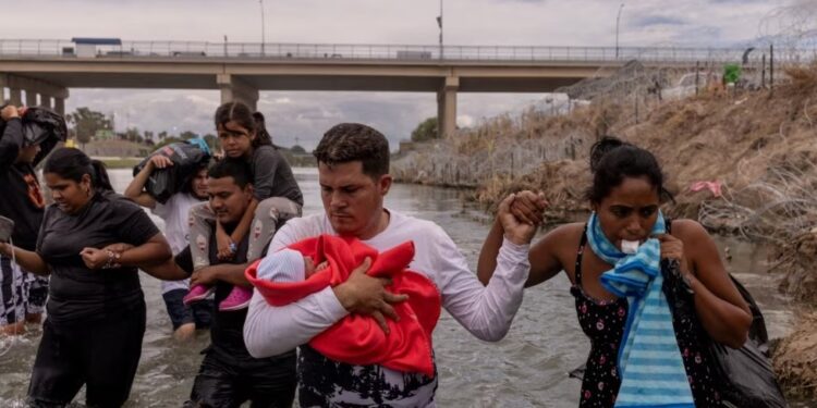 ARCHIVO - Yusniel, un migrante de Cuba, sostiene a su hijo de 10 días, Yireht, y a su esposa, Yanara, mientras buscan un punto de entrada más allá de una cerca de alambre a lo largo de la orilla del río Grande en Eagle Pass, Texas, EEUU, el 6 de octubre de 2023.