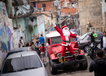 AME4589. CARACAS (VENEZUELA), 15/12/2023.- Un Papá Noel trabaja hoy durante la jornada "Un Juguete, una Buena Noticia", en la parroquia Petare en Caracas (Venezuela). Una treintena de trabajadores de la prensa de Venezuela, acompañados por Santa Claus, entregaron este viernes más de 400 regalos a niños que viven en varios sectores de Petare, la favela más grande del país, como parte de la iniciativa 'Un juguete, una buena noticia', promovida por periodistas. EFE/ Rayner Peña R