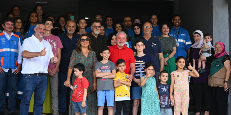 AME6287. BRASILIA (BRASIL), 25/12/2023.- El presidente de Brasil, Luiz Inácio Lula da Silva (c), posa con personas repatriadas de la Franja de Gaza en un almuerzo hoy, en la Base Aérea Militar de Brasilia (Brasil). Lula da Silva visitó este lunes a un grupo de brasileños y parientes palestinos repatriados el pasado sábado desde la Franja de Gaza y les garantizó apoyo hasta que estén instalados en el país suramericano. EFE/Andre Borges