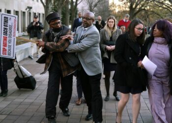 WASHINGTON, DC - DECEMBER 15: A member of security gets into an altercation with a protester as Georgia election worker Ruby Freeman leaves the E. Barrett Prettyman U.S. District Courthouse on December 15, 2023 in Washington, DC. A jury has ordered Rudy Giuliani, the former personal lawyer for former U.S. President Donald Trump, to pay $148 million in damages to the two Fulton County election workers, Freeman and her daughter Shaye Moss.   Alex Wong/Getty Images/AFP (Photo by ALEX WONG / GETTY IMAGES NORTH AMERICA / Getty Images via AFP)