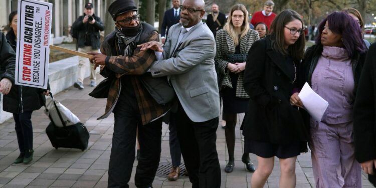 WASHINGTON, DC - DECEMBER 15: A member of security gets into an altercation with a protester as Georgia election worker Ruby Freeman leaves the E. Barrett Prettyman U.S. District Courthouse on December 15, 2023 in Washington, DC. A jury has ordered Rudy Giuliani, the former personal lawyer for former U.S. President Donald Trump, to pay $148 million in damages to the two Fulton County election workers, Freeman and her daughter Shaye Moss.   Alex Wong/Getty Images/AFP (Photo by ALEX WONG / GETTY IMAGES NORTH AMERICA / Getty Images via AFP)