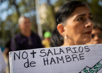 CARACAS (VENEZUELA), 09/01/2023.- Una mujer sostiene una pancarta que dice "No más salarios de hambre" durante una protesta para exigir aumento salarial y de pensiones, hoy, en Caracas (Venezuela). Cientos de trabajadores públicos protestaron este martes en Caracas y en buena parte de Venezuela contra los "salarios de hambre" que aseguran devengar, y para exigir ingresos "dignos" que les permitan cubrir sus necesidades básicas, así como por el "hostigamiento laboral". EFE/ Rayner Peña R.