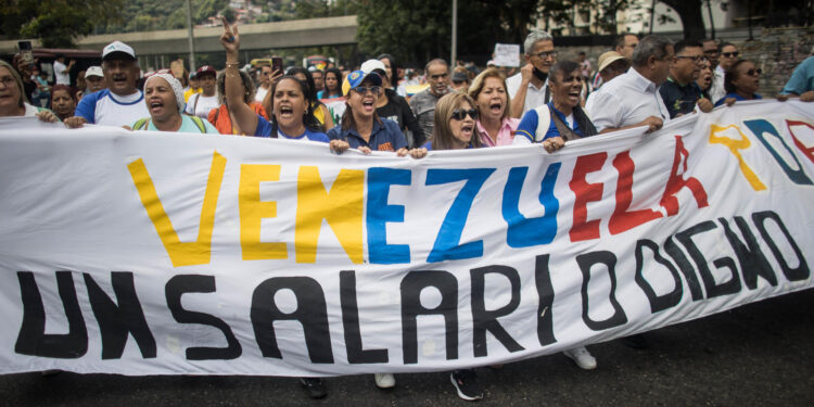 AME082. CARACAS (VENEZUELA), 15/01/2024.- Un grupo de maestros, respaldados por trabajadores de otros sectores, participan en una protesta contra los bajos salarios y para exigir mejoras laborales, hoy, en Caracas (Venezuela). Cientos de maestros en Venezuela volvieron a las calles este lunes, cuando se conmemora su día en el país, con el objetivo de exigir al Gobierno de Nicolás Maduro la reanudación de las negociaciones para una nueva convención colectiva. Esta es la segunda jornada de manifestaciones de trabajadores de este año, que comenzaron el pasado 9 de enero. EFE/ Miguel Gutiérrez