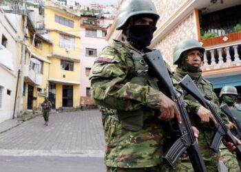 Members of the Armed Forces patrol a street during an operation to protect civil security in Quito, on January 10, 2024. Ecuador's president Daniel Noboa gave orders on Tuesday to "neutralize" criminal gangs after gunmen stormed and opened fire in a TV studio, as bandits threatened random executions on a second day of terror in the country. Gangs declared war on the government after Noboa announced a state of emergency following the prison escape on January 7 of one of Ecuador's most powerful narco bosses. (Photo by STRINGER / AFP)