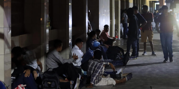 AME1022. SAN PEDRO SULA (HONDURAS), 19/01/2024.- Migrantes de diferentes nacionalidades descansan en la Gran Central Metropolitana donde se preparan para salir en caravana con destino a los Estados Unidos, hoy en la ciudad San Pedro Sula (Honduras). EFE/José Valle