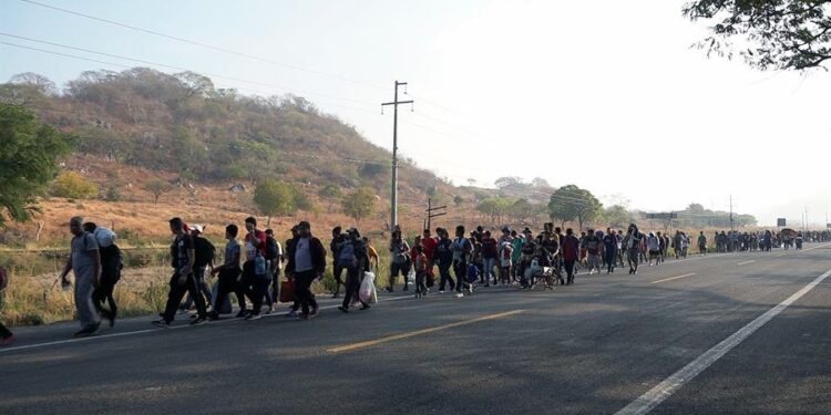 Migrantes caminan durante una caravana que se dirige a la frontera con Estados Unidos hoy, en el municipio de San Pedro Tapanatepec en el estado de Oaxaca (México). Las siete horas de caminata, algunas bajo el intenso sol, para 30 kilómetros recorrido, en su paso por el estado de Oaxaca, sur de México, minaron físicamente este martes a una parte la caravana migrante 'Éxodo de la pobreza' que se reagrupó luego de que el Gobierno mexicano la disolvió hace una semana tras partir desde Chiapas como la más numerosa de 2023. EFE/ Jesús Méndez