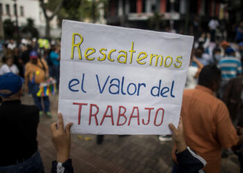 AME082. CARACAS (VENEZUELA), 15/01/2024.- Una persona sostiene un cartel de protesta durante una manifestación de maestros, respaldados por trabajadores de otros sectores, contra los bajos salarios y para exigir mejoras laborales, hoy, en Caracas (Venezuela). Cientos de maestros en Venezuela volvieron a las calles este lunes, cuando se conmemora su día en el país, con el objetivo de exigir al Gobierno de Nicolás Maduro la reanudación de las negociaciones para una nueva convención colectiva. Esta es la segunda jornada de manifestaciones de trabajadores de este año, que comenzaron el pasado 9 de enero. EFE/ Miguel Gutiérrez
