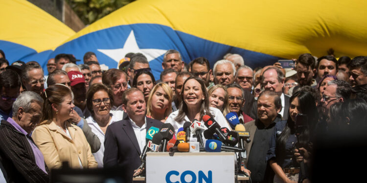 AME3081. CARACAS (VENEZUELA), 29/01/2024.- La líder opositora venezolana María Corina Machado (c) ofrece hoy declaraciones a la prensa durante un acto de calle, en Caracas (Venezuela). Machado aseguró este lunes que competirá en las presidenciales de este año, como candidata del mayor bloque antichavista, pese a la sentencia publicada el viernes en la que el Tribunal Supremo de Jsuticia (TSJ) ratificó que está impedida para participar en comicios hasta 2036. EFE/ MIGUEL GUTIERREZ