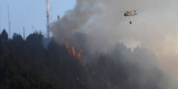 BOG400. BOGOTÁ (COLOMBIA), 24/01/2024.- Un helicóptero combate hoy un incendio forestal en el cerro El Cable, en Bogotá (Colombia). Un nuevo incendio, que ahonda la crisis medioambiental en Colombia, comenzó este miércoles en los cerros orientales de Bogotá, esta vez en uno conocido como El Cable y en donde las autoridades locales tratan de apagar las llamas. EFE/ Carlos Ortega