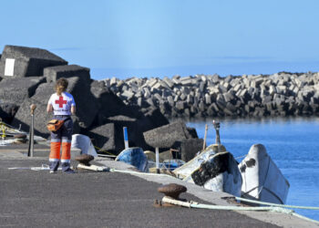 EL PINAR (EL HIERRO), 02/01/2024.- Una trabajadora de Cruz Roja observa los cayucos que se acumulan en el muelle de La Restinga, en el municipio de El Pinar, en la isla de El Hierro, tras las últimas llegadas de inmigrante a la isla. EFE/ Gelmert Finol