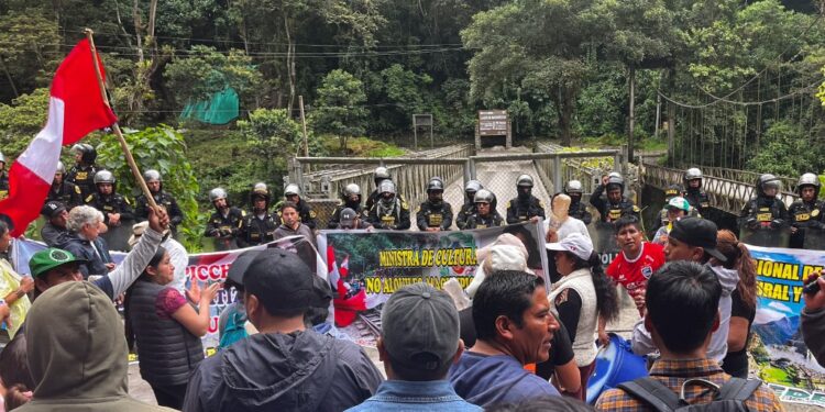 Members of the police stand guard at the entrance of the Machu Picchu ruins while tour operators and residents hold a strike and demonstration against the opening of online ticket sales to the ruins of the Inca citadel, in Machu Picchu Pueblo, Peru on January 26, 2024. Visitors to Peru's iconic Machu Picchu site were met Thursday by protesters angry with the government for privatizing ticket sales at the Inca citadel. Tour operators and residents closed shops in protest and blocked the tracks of a tourist train, compelling those on board to walk the remaining three kilometers (1.9 miles) to the entrance. (Photo by Carolina Paucar / AFP)