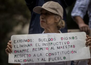 AME632. CARACAS (VENEZUELA), 18/01/2024.- Una persona muestra un cartel de protesta durante una manifestación de trabajadores que exigen mejores salarios y condiciones laborales, el 15 de enero de 2024, en Caracas (Venezuela). Los trabajadores públicos de Venezuela inician otro año de protestas contra los "salarios de hambre", una lucha que planean intensificar hasta que el clamor por un ingreso que satisfaga sus necesidades reciba, finalmente, una respuesta de las autoridades acorde a sus demandas, dijeron sindicalistas a EFE. Cientos de trabajadores llevaron a cabo el lunes la segunda jornada de manifestaciones de 2024, que finalizó con el anuncio del presidente Nicolás Maduro de un aumento de 30 a 60 dólares de una bonificación mensual sin incidencia en el cálculo de beneficios como las prestaciones, mientras que el salario mínimo se mantiene, desde marzo de 2022, en 130 bolívares, hoy 3,6 dólares al mes. EFE/ Miguel Gutiérrez