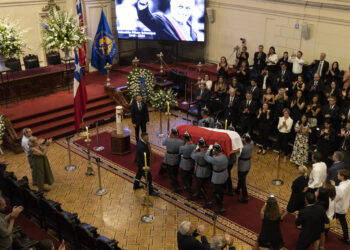 AME6842. SANTIAGO (CHILE), 07/02/2024.- Agentes sostienen el ataúd con el cuerpo del expresidente de Chile Sebastián Piñera hoy, en la antigua sede del Congreso en Santiago (Chile). El cortejo fúnebre con los restos del expresidente de Chile Sebastián Piñera, quien murió este martes en un accidente aéreo, llegaron a la antigua sede del Congreso, en el centro de la capital chilena, donde será velado y recibirá el último adiós de los chilenos previo al funeral de Estado previsto para el viernes. EFE/ Ailen Díaz