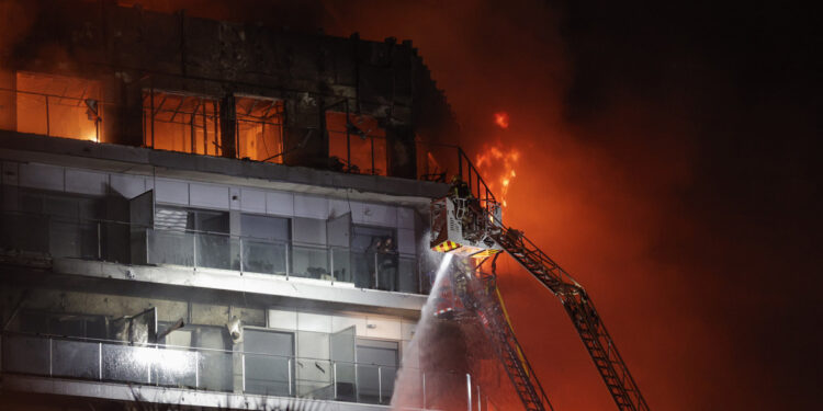 VALENCIA, 22/02/2024.- Vista del incendio declarado sobre las cinco y media de esta tarde en un quinto piso de un edificio de viviendas de València que ha afectado totalmente al inmueble y se ha propagado a otro anexo, y los bomberos intentan aún rescatar a vecinos desde los balcones. EFE/Manuel Bruque