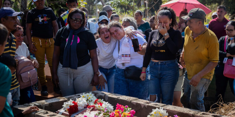 AME1272. LA PARAGUA (VENEZUELA), 22/02/2024.- Familiares se lamentan junto al féretro de una de las victimas mortales del derrumbe en la mina 'Bulla Loca', durante su entierro este jueves, en La Paragua (Venezuela). Al menos 16 personas resultaron heridas tras el derrumbe en una mina ilegal del estado Bolívar, en el sur de Venezuela, informó el gobernador de esta región fronteriza con Brasil, Ángel Marcano, con lo que se eleva el número de lesionados, que hasta el miércoles eran 11, mientras que la cifra oficial de fallecidos se mantiene en 16. El funcionario dijo que los heridos por el siniestro en la mina ilegal 'Bulla Loca', ocurrido cuando había un "grupo considerable" de personas, están estables, de los cuales tres fueron trasladados a centros sanitarios, y aseguró que continúan las labores de rescate realizadas por diversas entidades gubernamentales. EFE/ Rayner Peña R