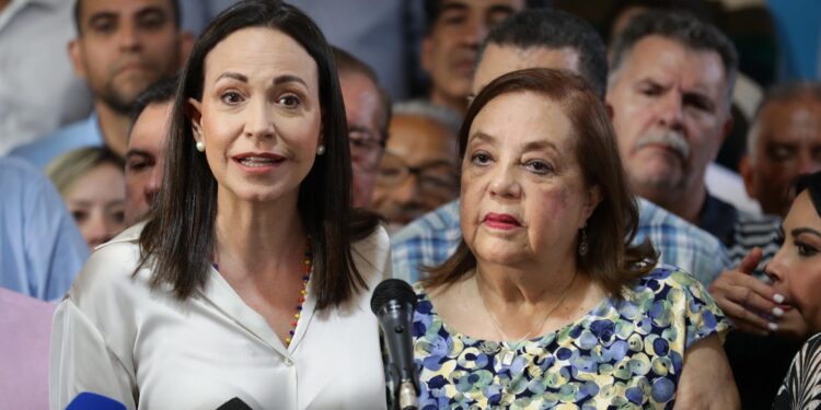 AME1083. CARACAS (VENEZUELA), 22/03/2024.- La líder antichavista María Corina Machado (izq.) presenta durante una rueda de prensa a la historiadora Corina Yoris (der.) como candidata para las elecciones presidenciales del próximo 28 de julio, en vista de la inhabilitación que impide competir a la política, hoy en Caracas (Venezuela). En declaraciones a la prensa, Machado aseguró que la decisión "surgió del seno de la discusión de las fuerzas unitarias" y forma parte de un mecanismo acordado para hacer "frente a este obstáculo", en referencia a su inhabilitación, ratificada en enero por el Tribunal Supremo de Justicia (TSJ), una sanción a la calificó como "un acto írrito, totalmente inconstitucional y cobarde". EFE/ Rayner Peña R.